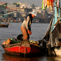 A woman stands near houseboat in Chau Doc, Vietnam.