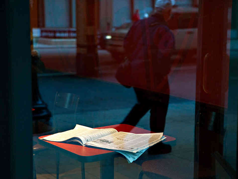 An open newspaper on a cafe table
