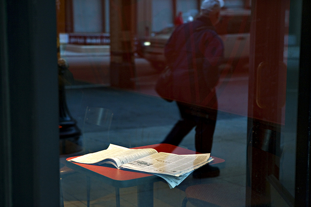 An open newspaper on a cafe table