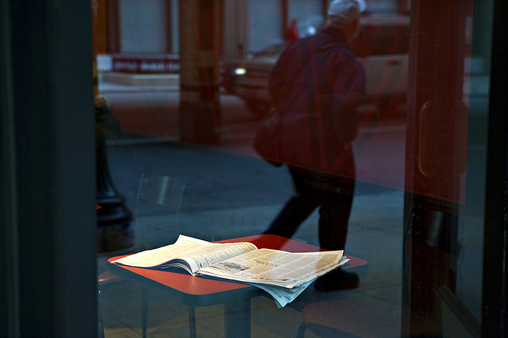 An open newspaper on a cafe table