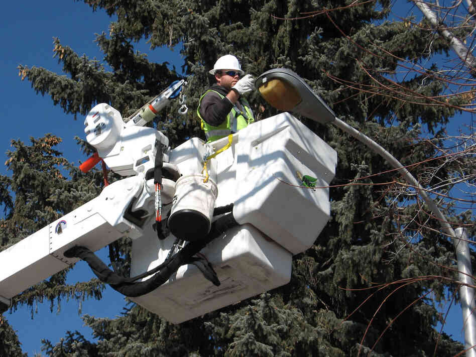 A utility worker turns off a Colorado Springs street light. Jeff Brady/NPR