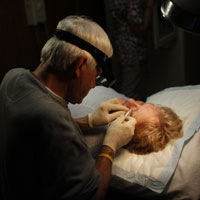 Physician Assistant Tom Harward performs minor surgery at the Belington Clinic in Belington, W.Va.