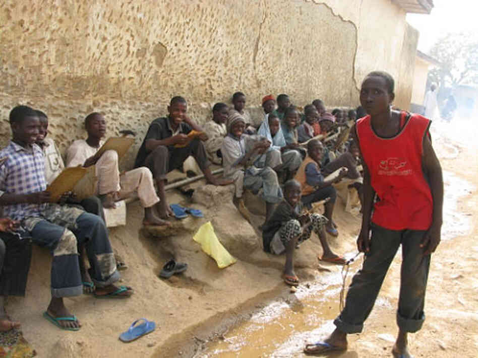 Young boys receive orders from their monitor, right, at a Koranic boarding school. Young boys receive orders from their monitor, right, at a Koranic boarding school.