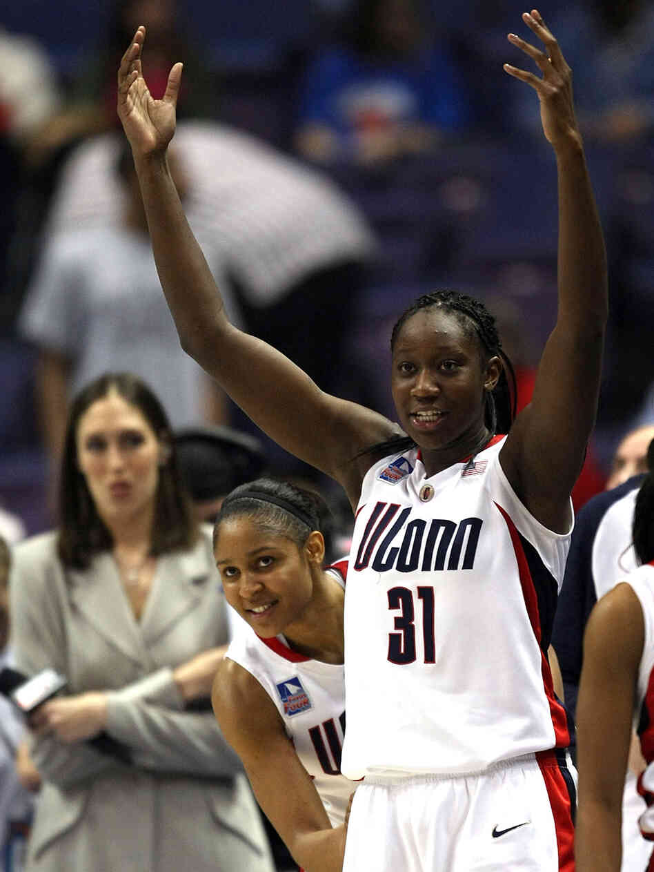 Maya Moore peeks around teammate Tina Charles as the Connecticut Huskies celebrate victory.