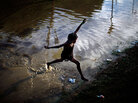 A girl jumps across a flooded field in Port-au-Prince. A girl jumps across a flooded field in Port-au-Prince.