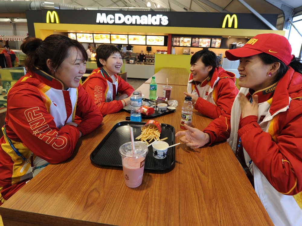 Chinese short-track speedskaters eat in the dining hall during a media tour of the Olympic Village.