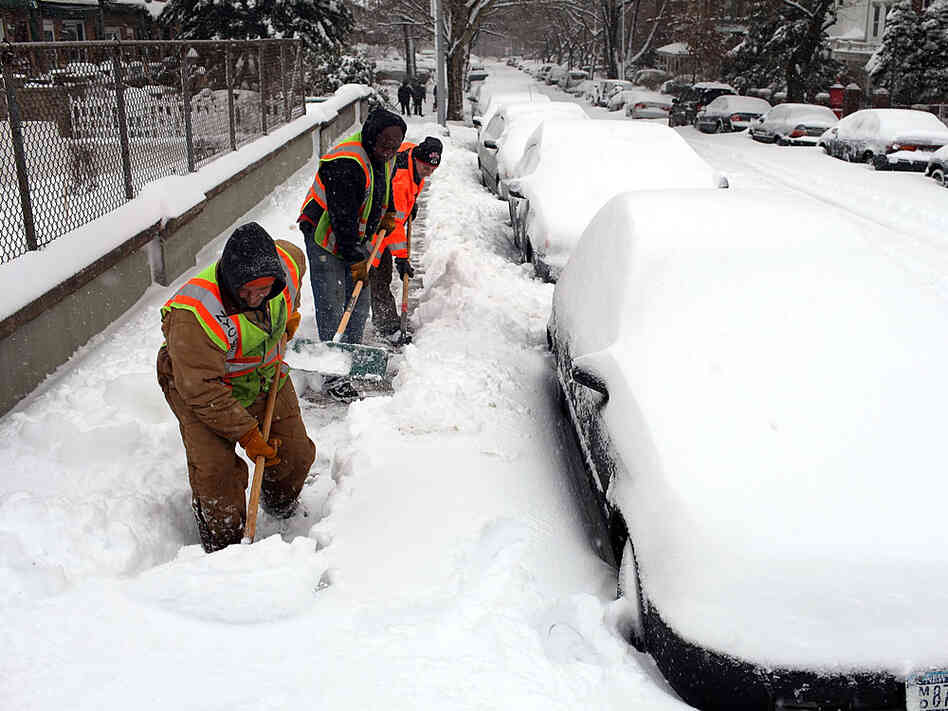 Workers clear an overpass of snow in New York City