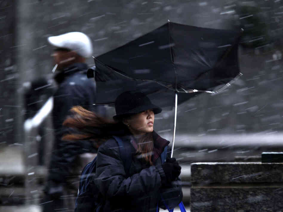 A woman's umbrella was turned inside out from a gust of wind during a winter storm in Philadelphia.