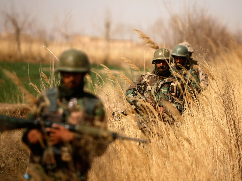 Afghan National Army soldiers patrol outside Marjah