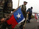 Soldiers and rescue workers carrying damaged Chilean flags search for victims. Soldiers and rescue workers carrying damaged Chilean flags search for victims.