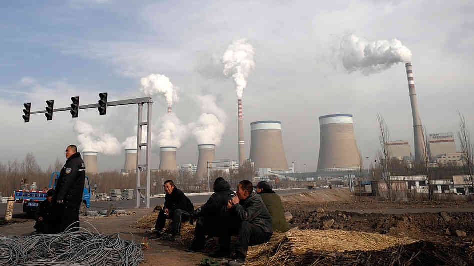 Workers rest in front of the cooling towers of a coal-fired power plant in Dadong, Shanxi . Workers rest in front of the cooling towers of a coal-fired power plant in Dadong, Shanxi .