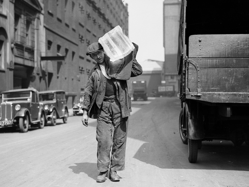 A worker distributes a block of ice in 1936.
