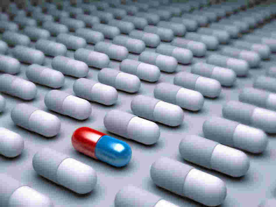 An red and blue pill amid many gray pills lined up. An red and blue pill amid many gray pills lined up.