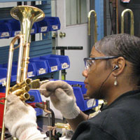 An employee cleans sections of a trumpet at Conn-Selmers' Vincent Bach division.