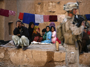 A U.S. Marine office guards an Afghan family in Trikh Nawar. A U.S. Marine office guards an Afghan family in Trikh Nawar.