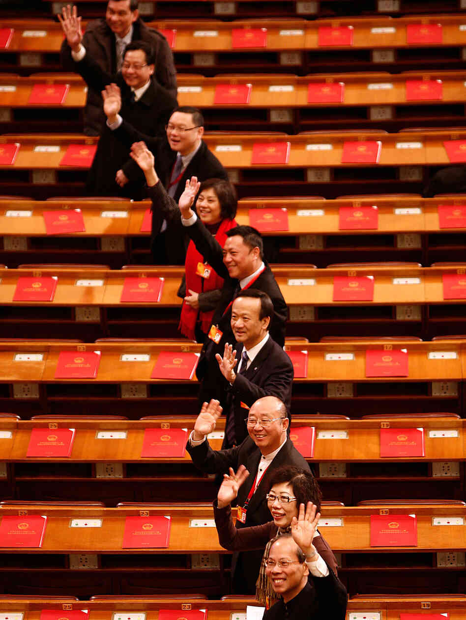 Delegates gesture as they arrive for a session Sunday of the National People's Congress Delegates gesture as they arrive for a session Sunday of the National People's Congress