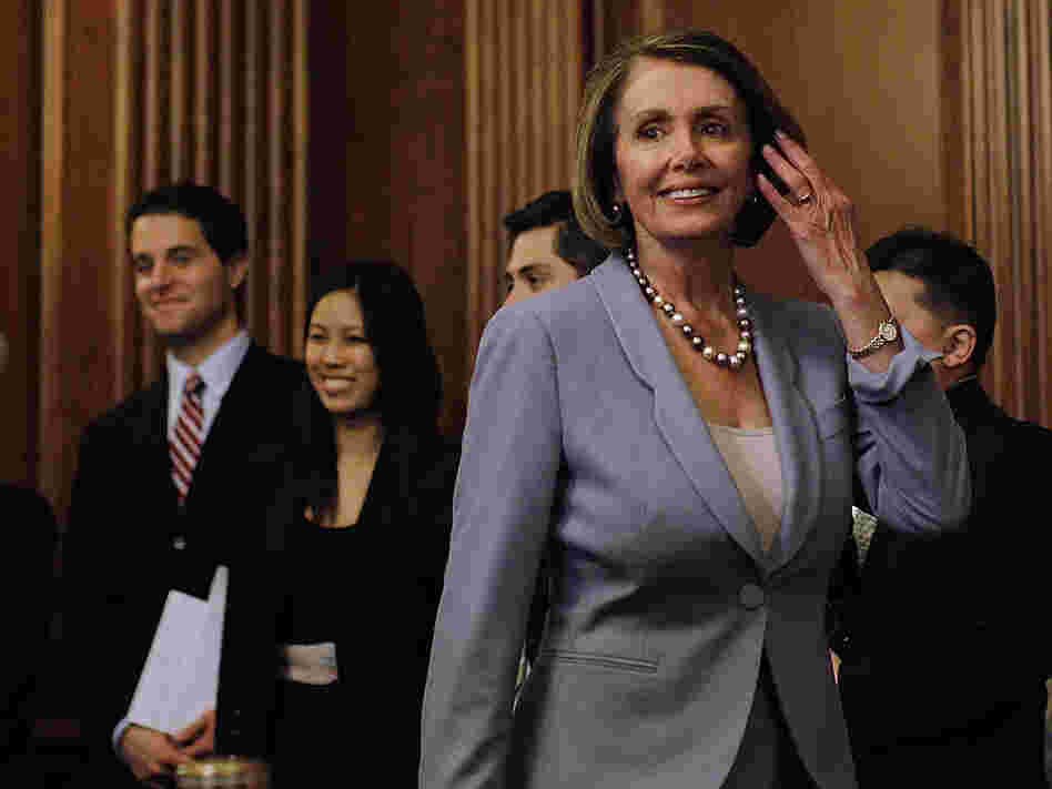 House Speaker Nancy Pelosi walks past House staff as she arrives to give a speech on health care.
