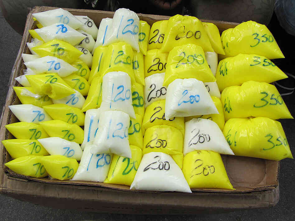 In markets in Kingston, Jamaica, women buy bleaching products sold in plastic bags without labels.