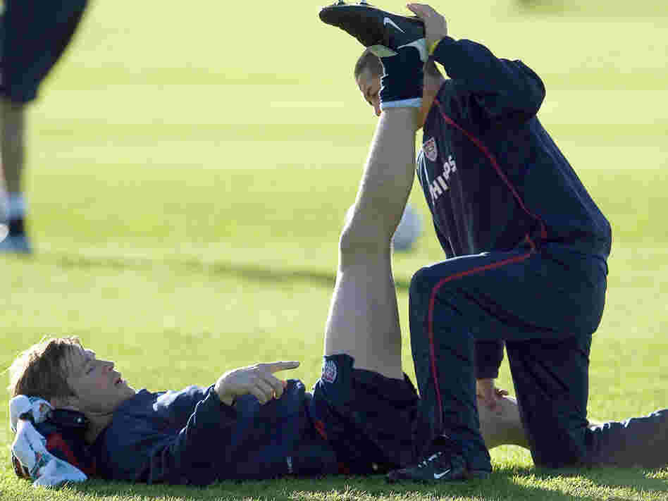 Soccer players stretch.