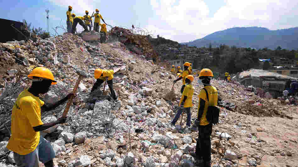 Workers remove rubble from a destroyed school in Port-Au-Prince.