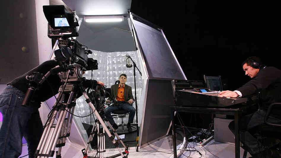An actor prepares to receive fake shocks on a staged TV game show. An actor prepares to receive fake shocks on a staged TV game show.