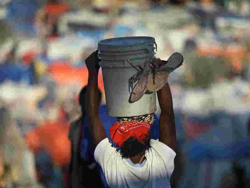 A woman carries water through a crowded refugee camp for earthquake victims on Feb. 7 in Haiti.