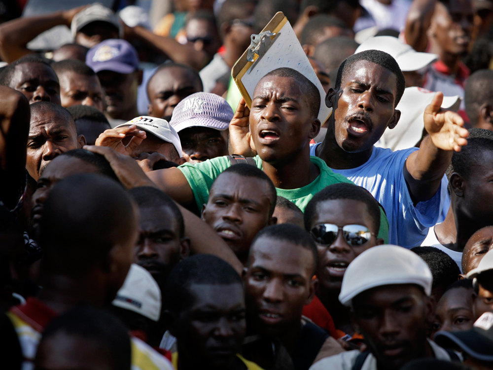 Unemployed earthquake survivors gather outside a job agency