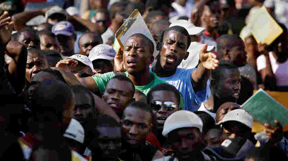 Unemployed earthquake survivors gather outside a job agency