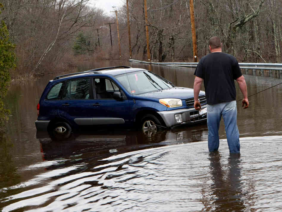 A tow truck operator checks on a car he is pulling out in Exeter, R.I. A tow truck operator checks on a car he is pulling out in Exeter, R.I.