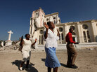 Haitians pray as they walk past the ruins of the National Cathedral. Haitians pray as they walk past the ruins of the National Cathedral.