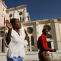 Haitians pray as they walk past the ruins of the National Cathedral.