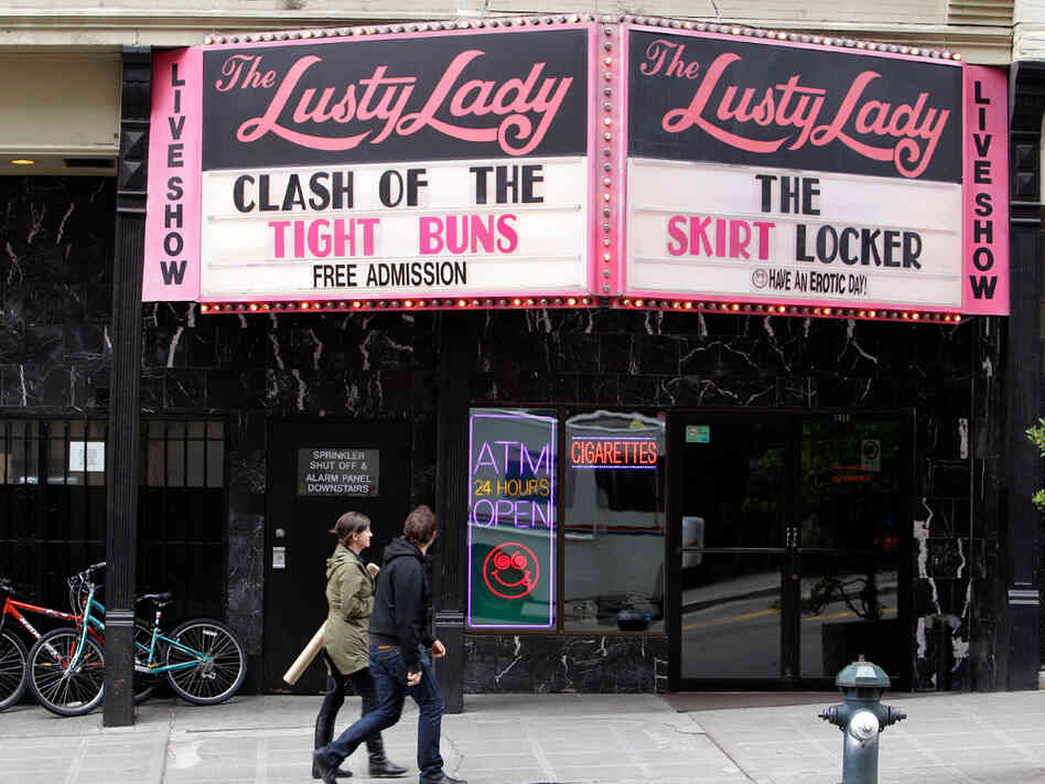 Pedestrians walk past the iconic marquee of The Lusty Lady in downtown Seattle.
