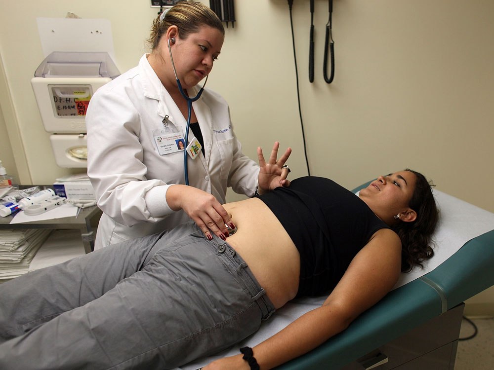 Maria Villa, who cannot afford insurance, has her pregnant belly examined in 2009.