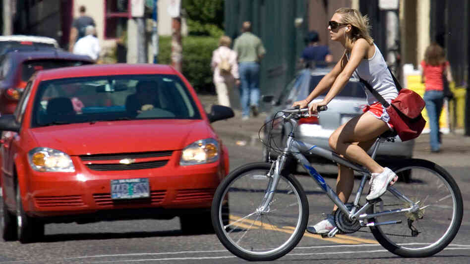 A bicyclist pedals through an intersection A bicyclist pedals through an intersection