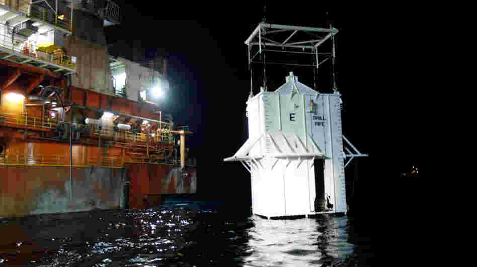The 100-ton containment vessel is lowered into the Gulf of Mexico.