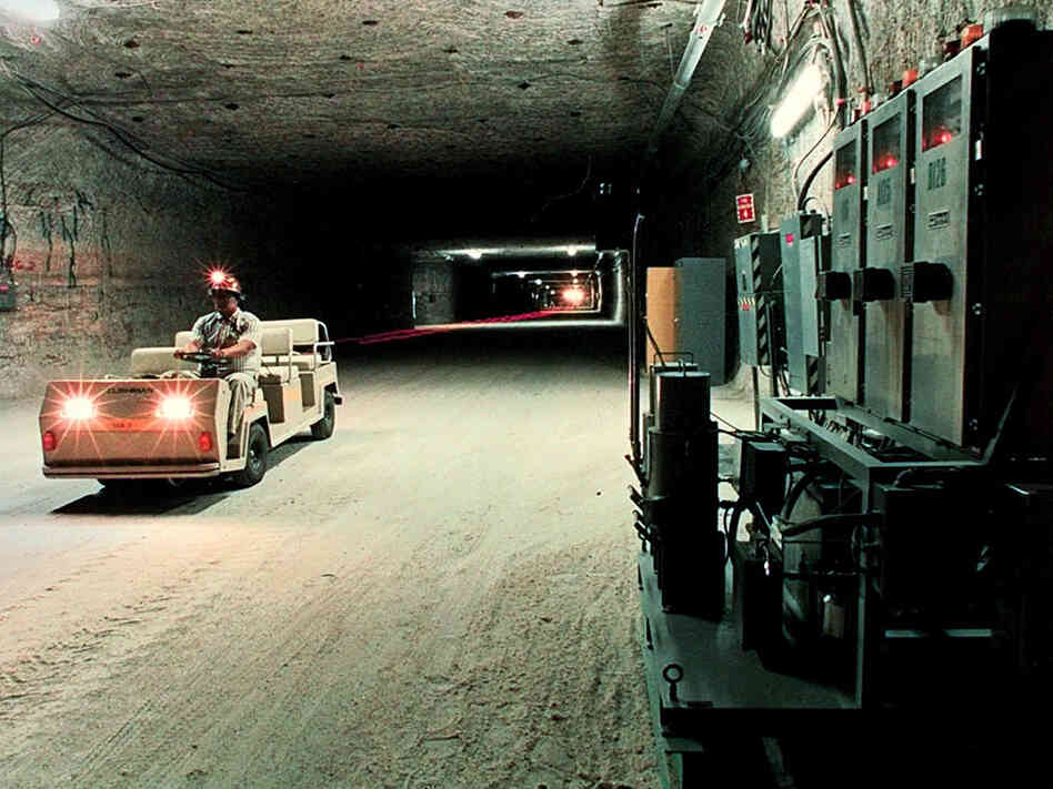 A worker drives an electric cart in a storage room of the Waste Isolation Pilot Plant.