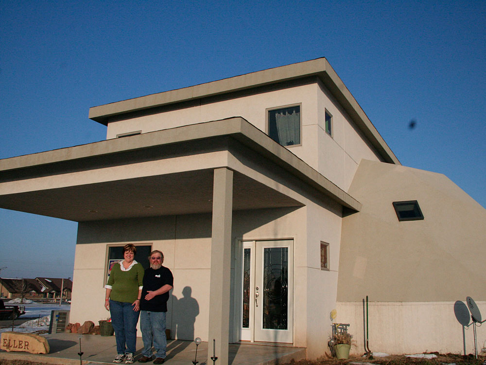 The Ellers stand in front of their rebuilt home in Greensburg, Kan.
