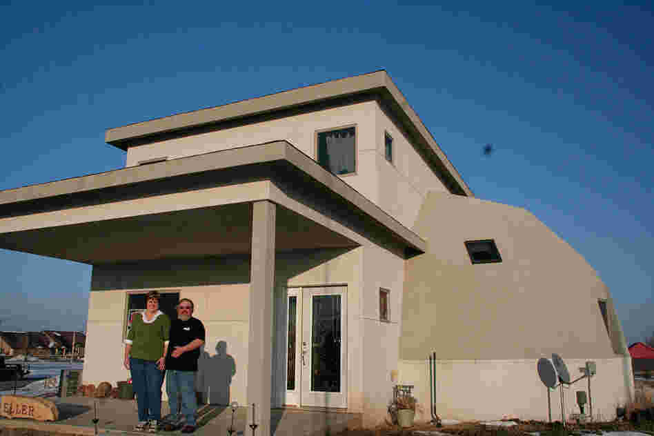 The Ellers stand in front of their rebuilt home in Greensburg, Kan.
