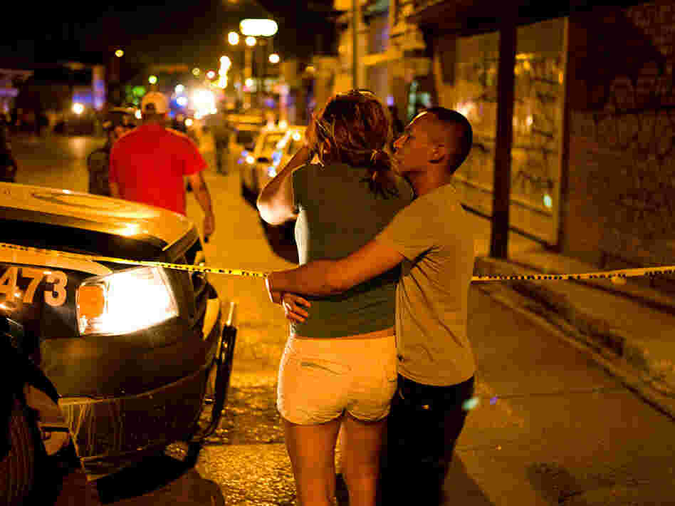 A man comforts a woman at a crime scene in Juarez