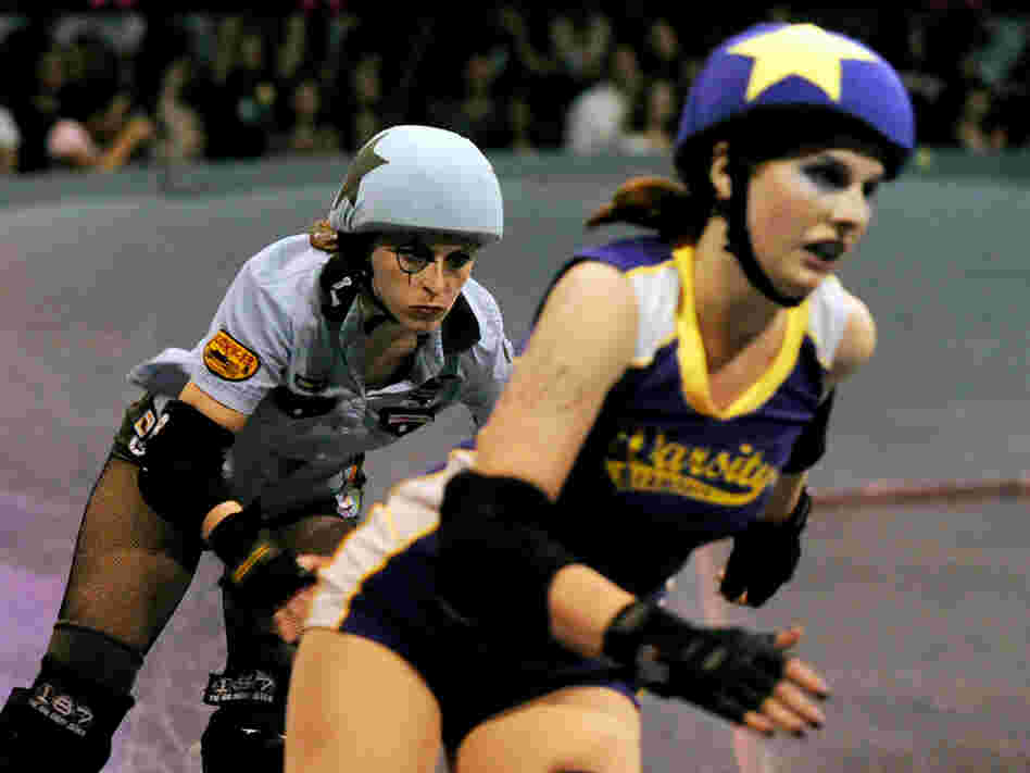 Skaters from the Tough Cookies (in blue) and the Varsity Brawlers (purple) are seen in action.