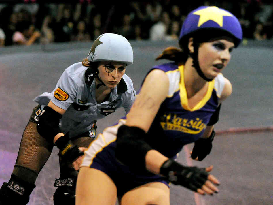 Skaters from the Tough Cookies (in blue) and the Varsity Brawlers (purple) are seen in action.