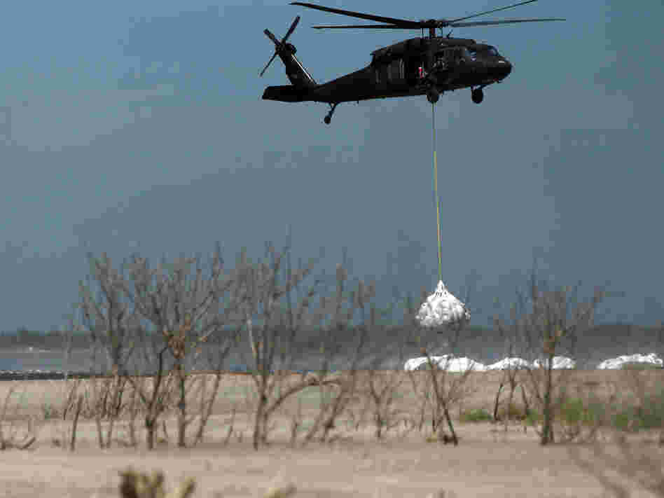 A Louisiana National Guard helicopter airlifts sandbags