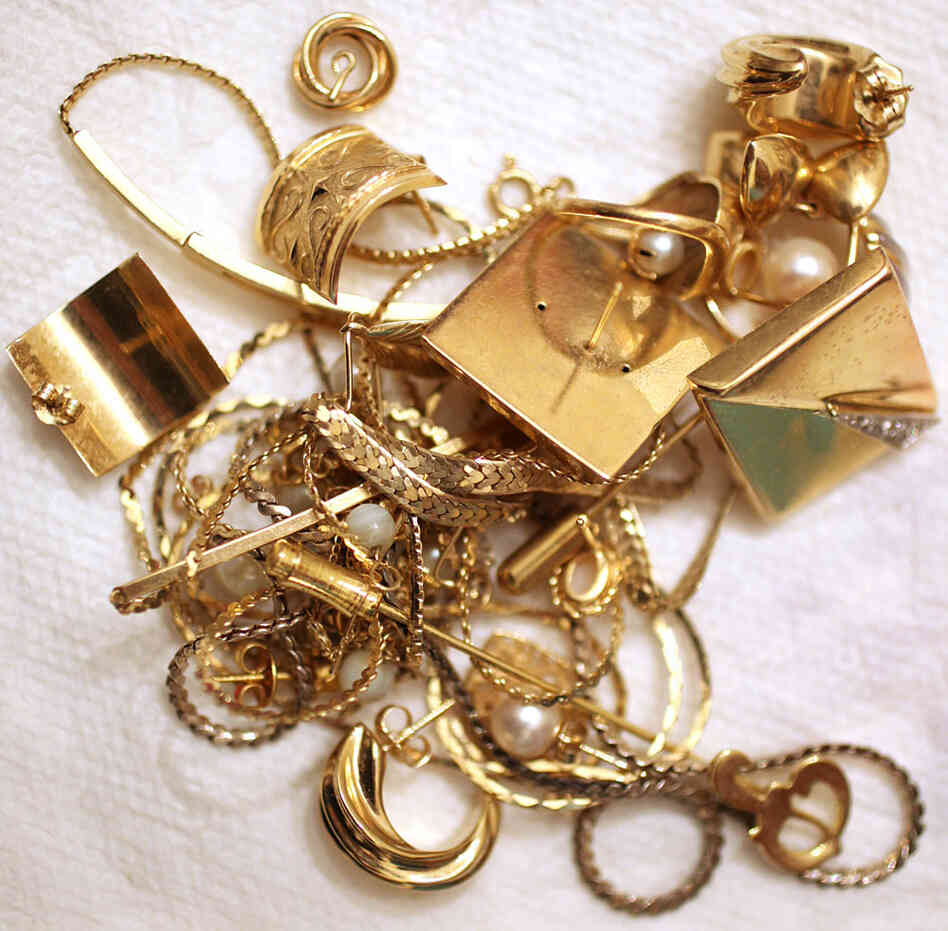 Gold jewelry pieces sit in a pile.