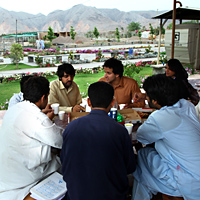 Students chat in an outdoor cafe on the campus of the Institute of Management Sciences.