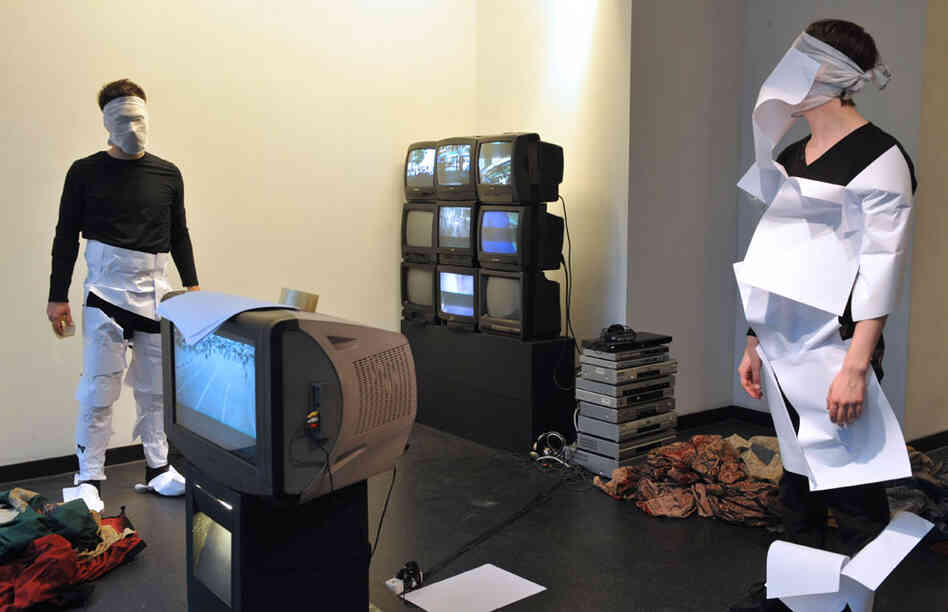 Dancers perform in front of TV sets displaying mobile phone videos from Iranian protesters
