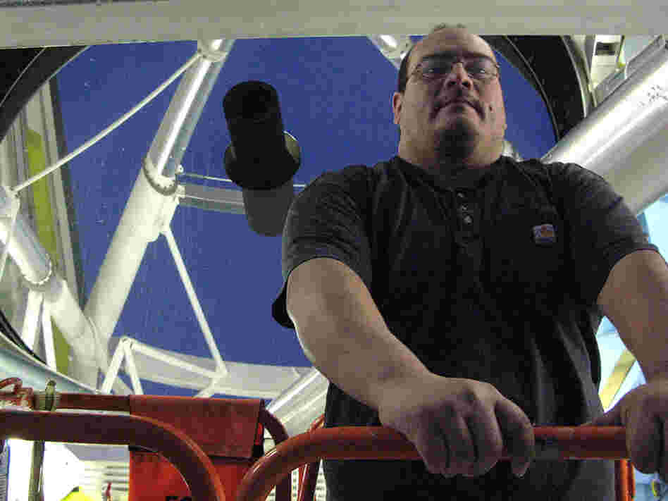 Michael Alegria with the Multiple Mirror Telescope he operates in Arizona.