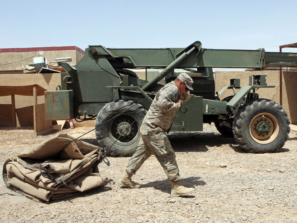 A U.S. soldier drags a tent as his unit prepares to leave its base northeast of Baghdad.
