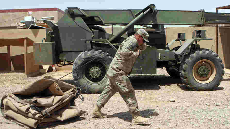 A U.S. soldier drags a tent as his unit prepares to leave its base northeast of Baghdad.