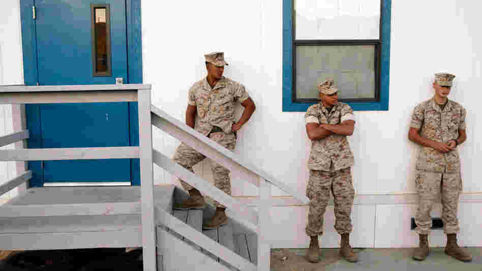 Three U.S. Marines waiting outside a building to take psychological tests