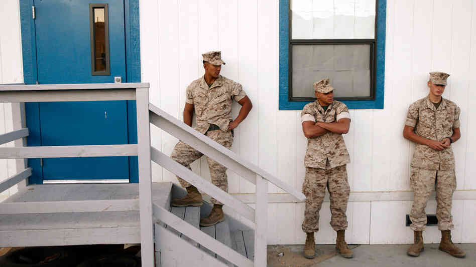 Three U.S. Marines waiting outside a building to take psychological tests